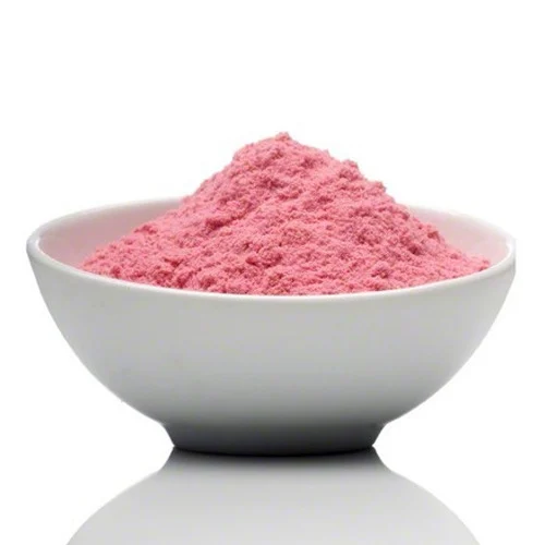 Pomegranate powder (Anardana) from The Plants Mall Pakistan in a clear glass jar with a stainless steel spoon, isolated on white background showing fine reddish-brown powder texture