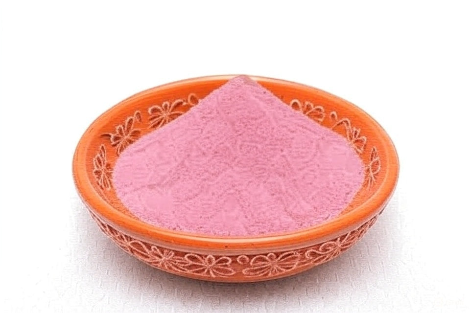 Rich meat curry simmering in a traditional pot, with pomegranate powder being added from a spoon